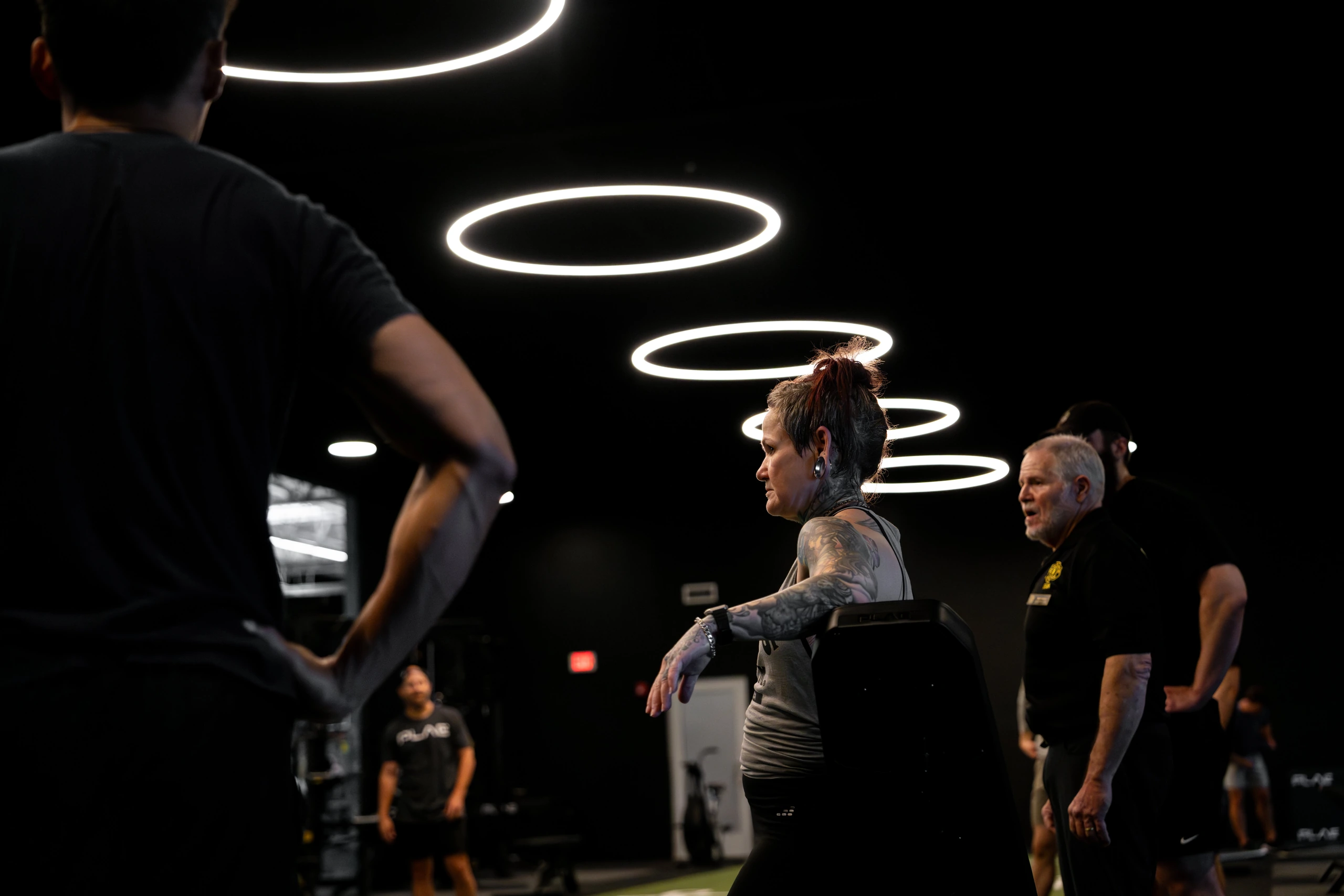 Members and a coach training together under the halo ring lights at Gold's Gym Austin