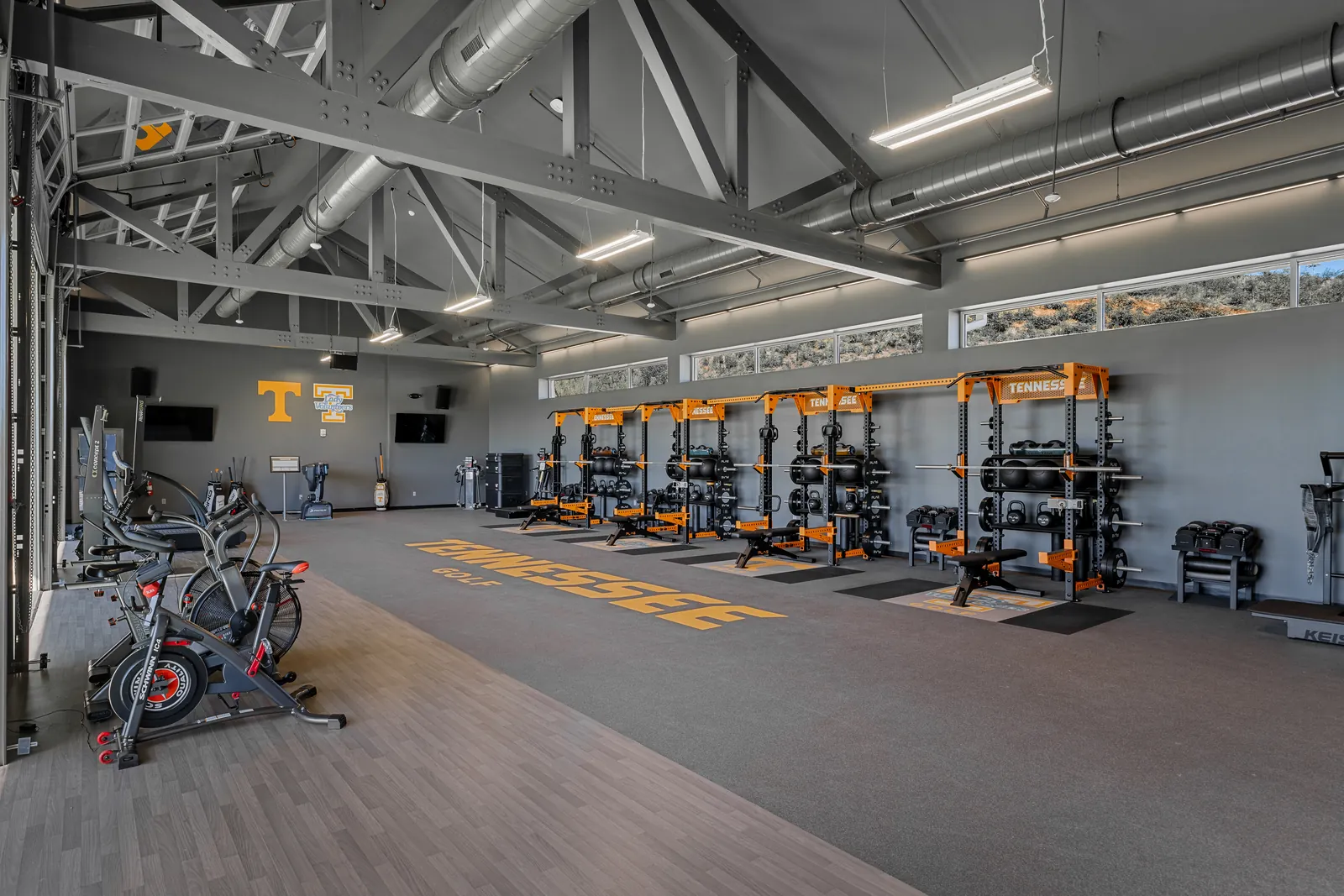 Wide view of the University of Tennessee golf strength and conditioning gym outfitted with PLAE racks, benches and custom PLAE flooring.