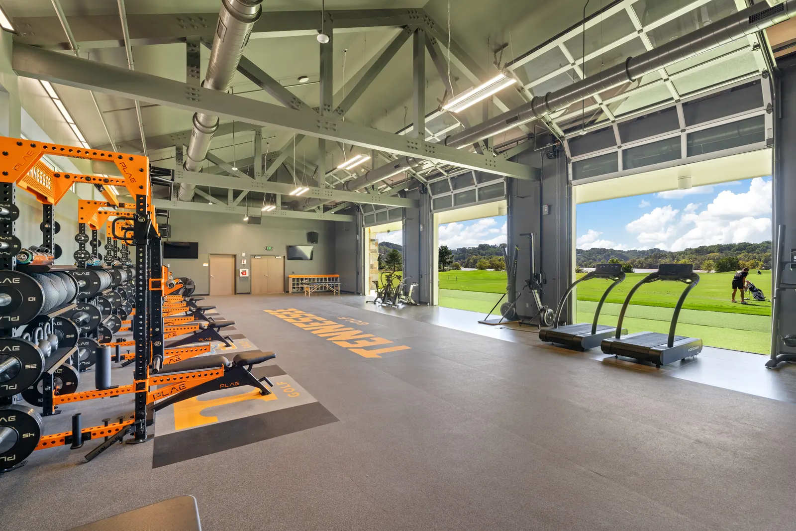 Wide view of the University of Tennessee golf strength and conditioning gym outfitted with PLAE racks, benches and custom PLAE flooring.