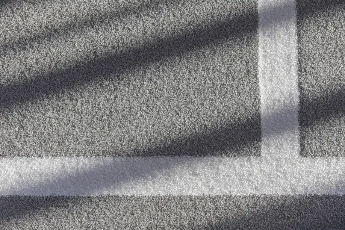 Detail of PLAE Attack turf flooring with inlaid white line markings and morning shadow at The Mill, Queenstown.