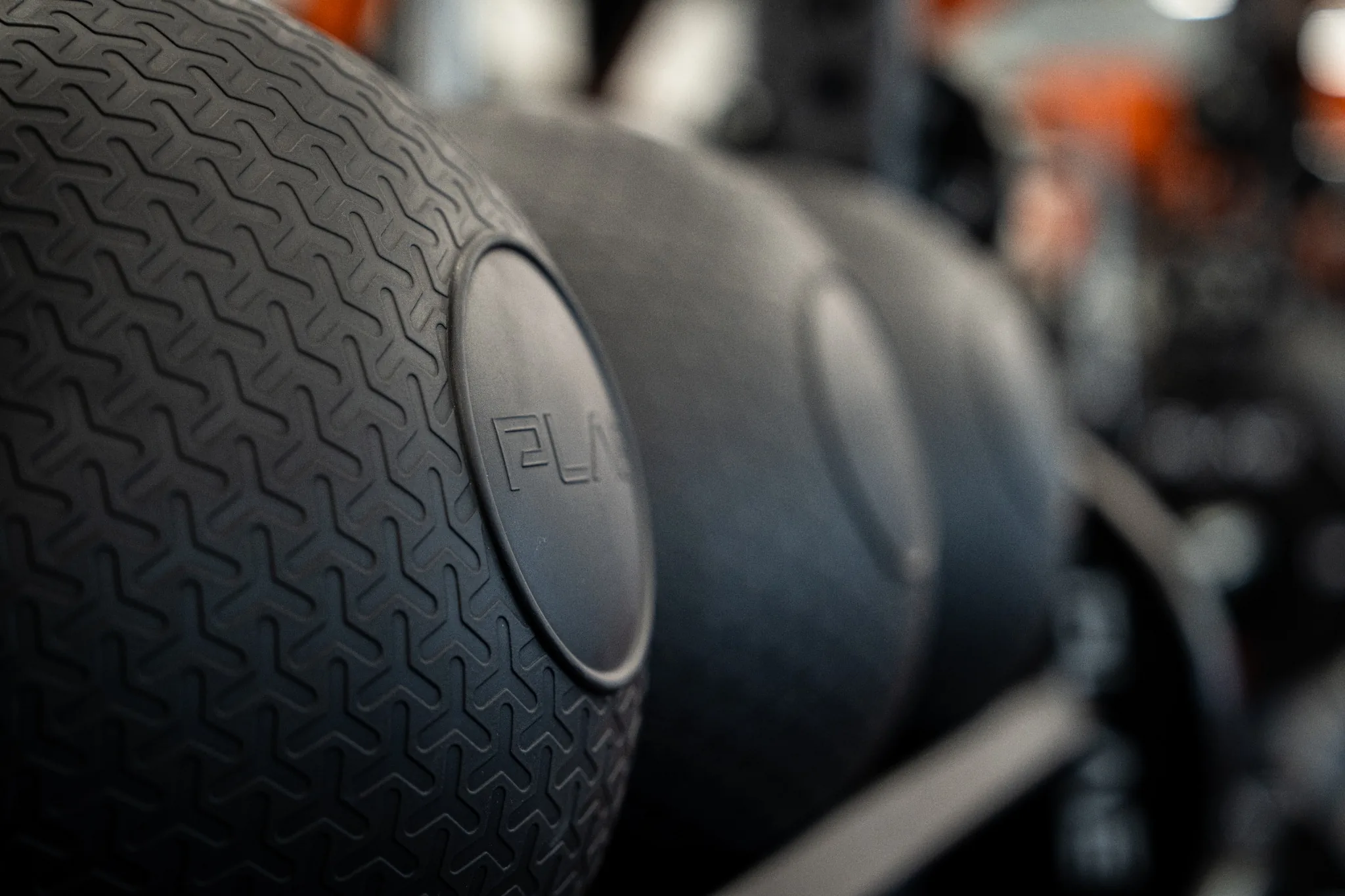 Close-up of textured PLAE medicine balls stored on custom branded ICONx rack shelving.