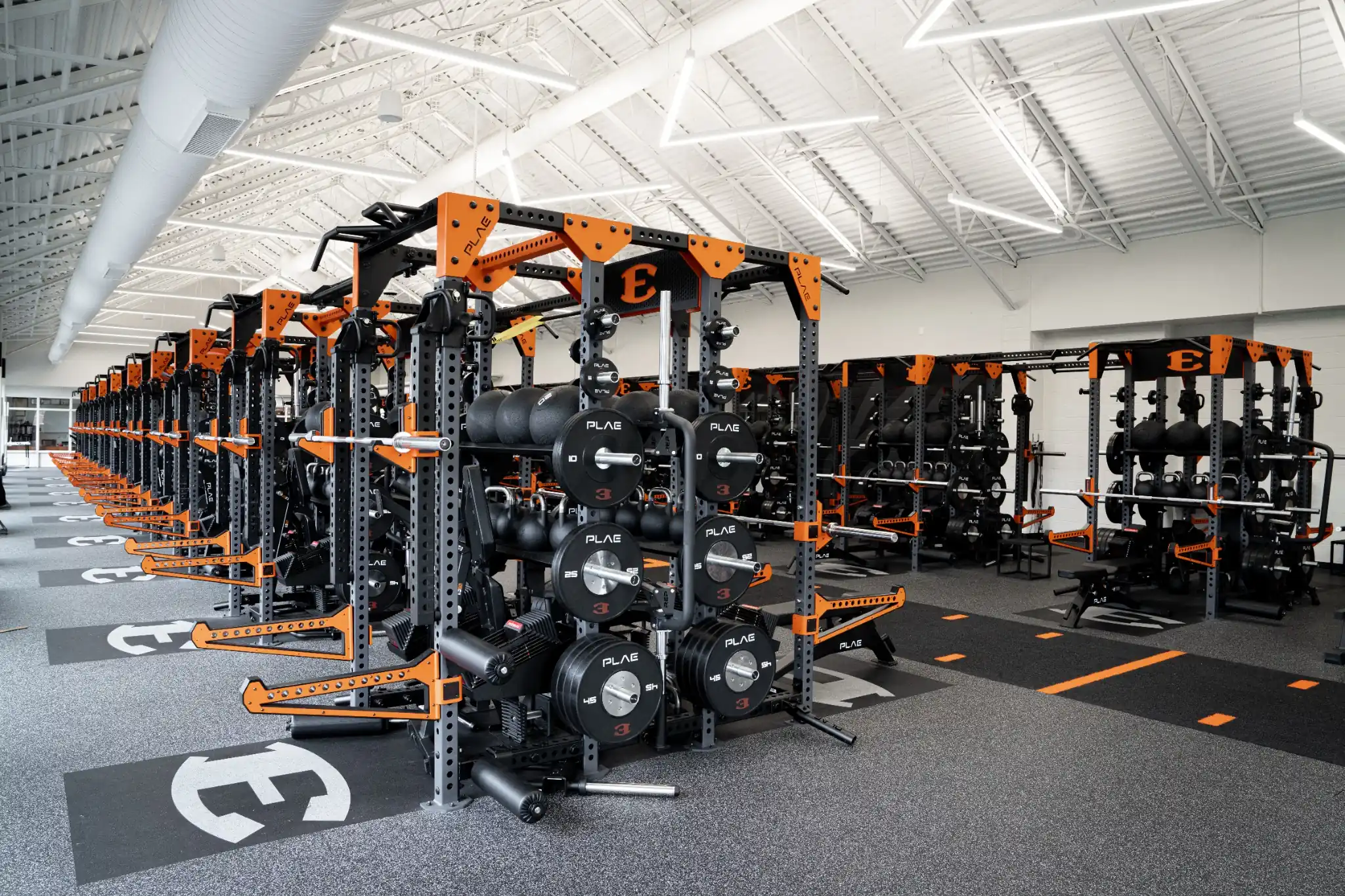 Elite collegiate strength facility fitted with custom branded PLAE ICONx racks, Attack turf and Achieve rubber flooring.