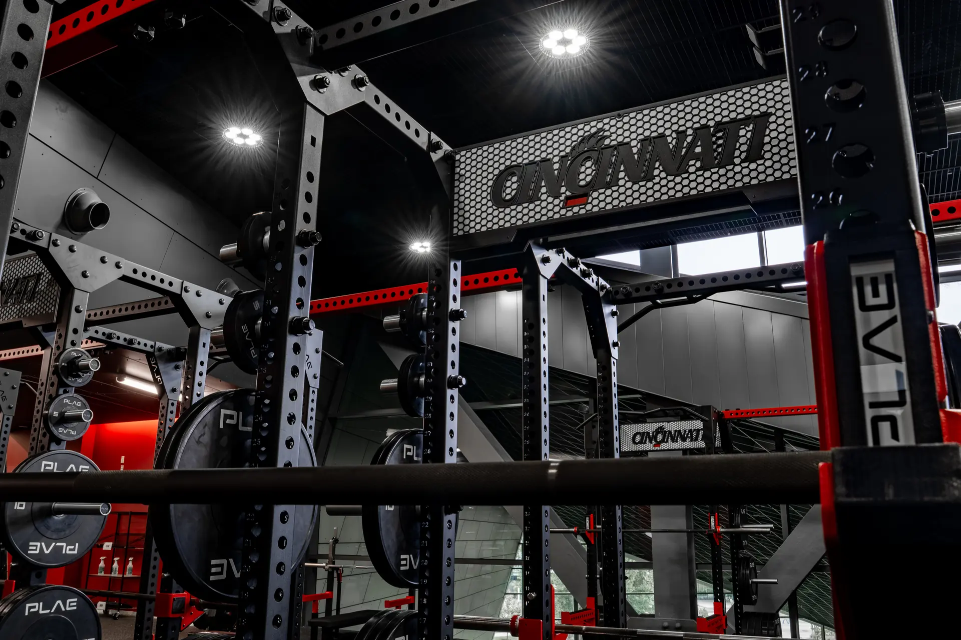 Close-up of a custom branded PLAE ICONx rack featuring a bespoke Cincinnati nameplate and integrated strength training system.