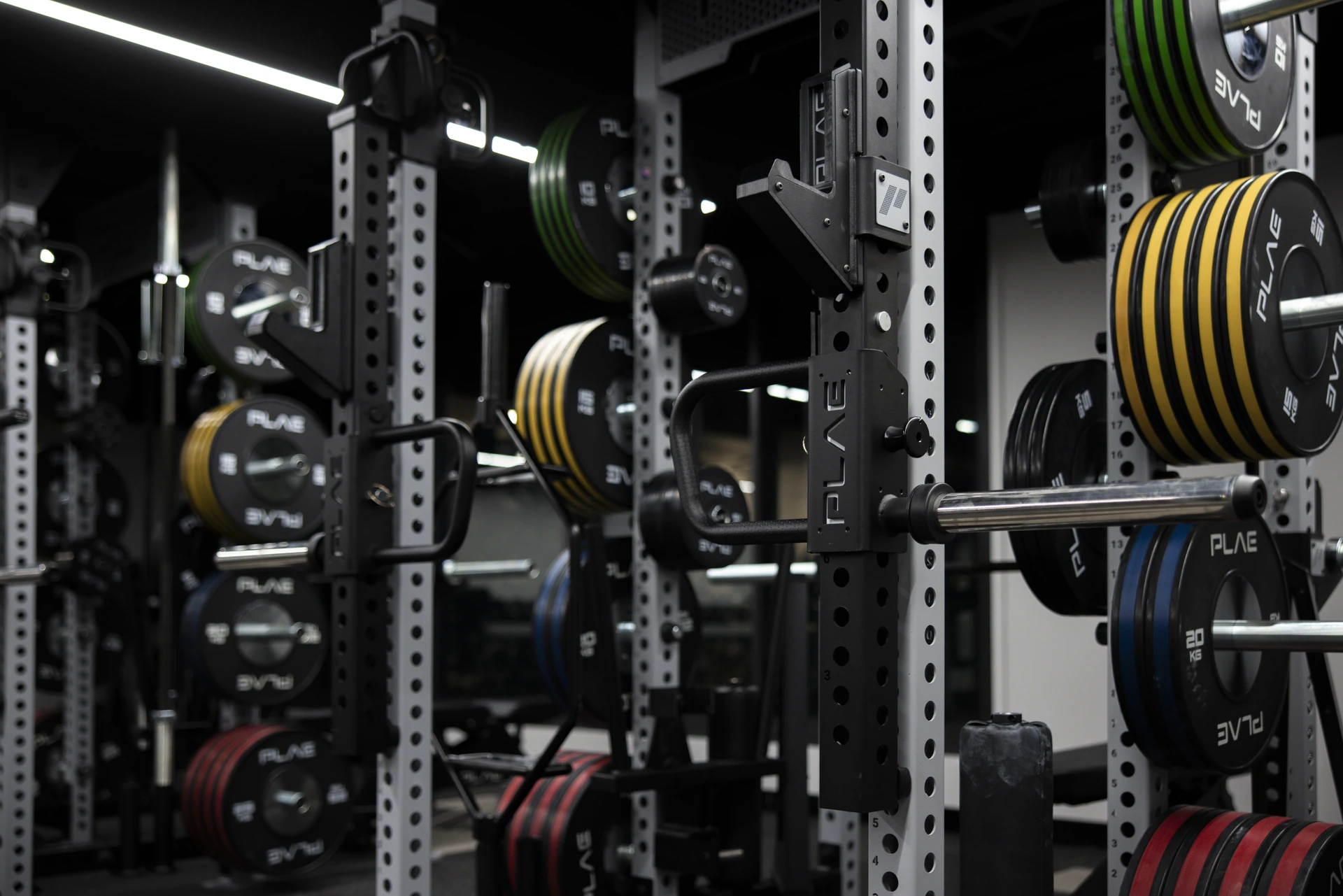Coloured bumper plates stored on ICONx rack plate horns at Athletes Authority