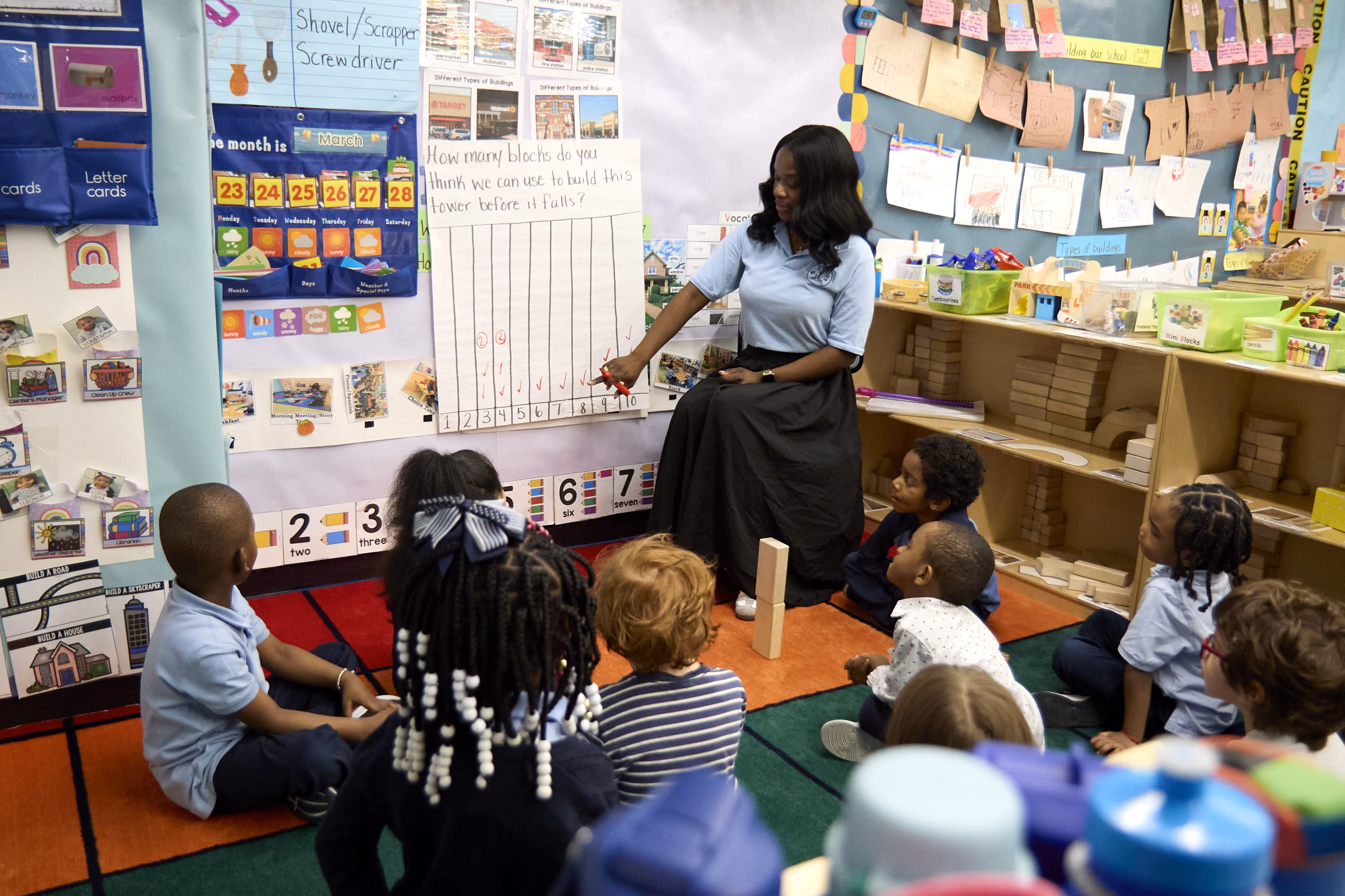 Teacher leads a math lesson with young students on classroom floor