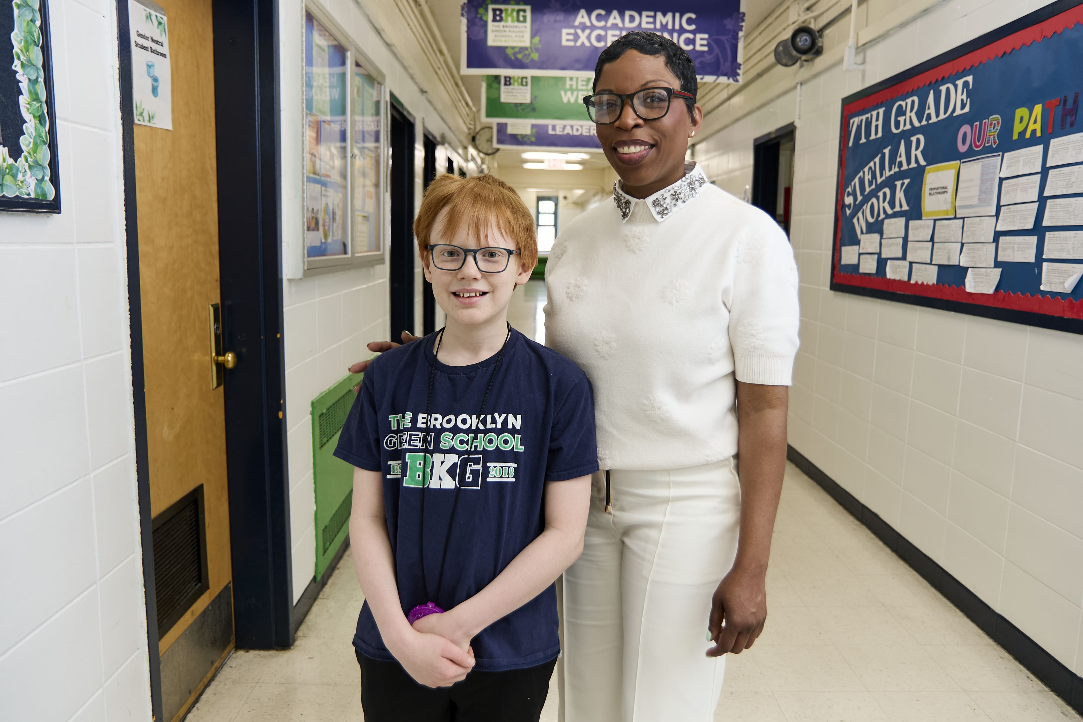 Student and staff member smiling together in Brooklyn Green School hallway