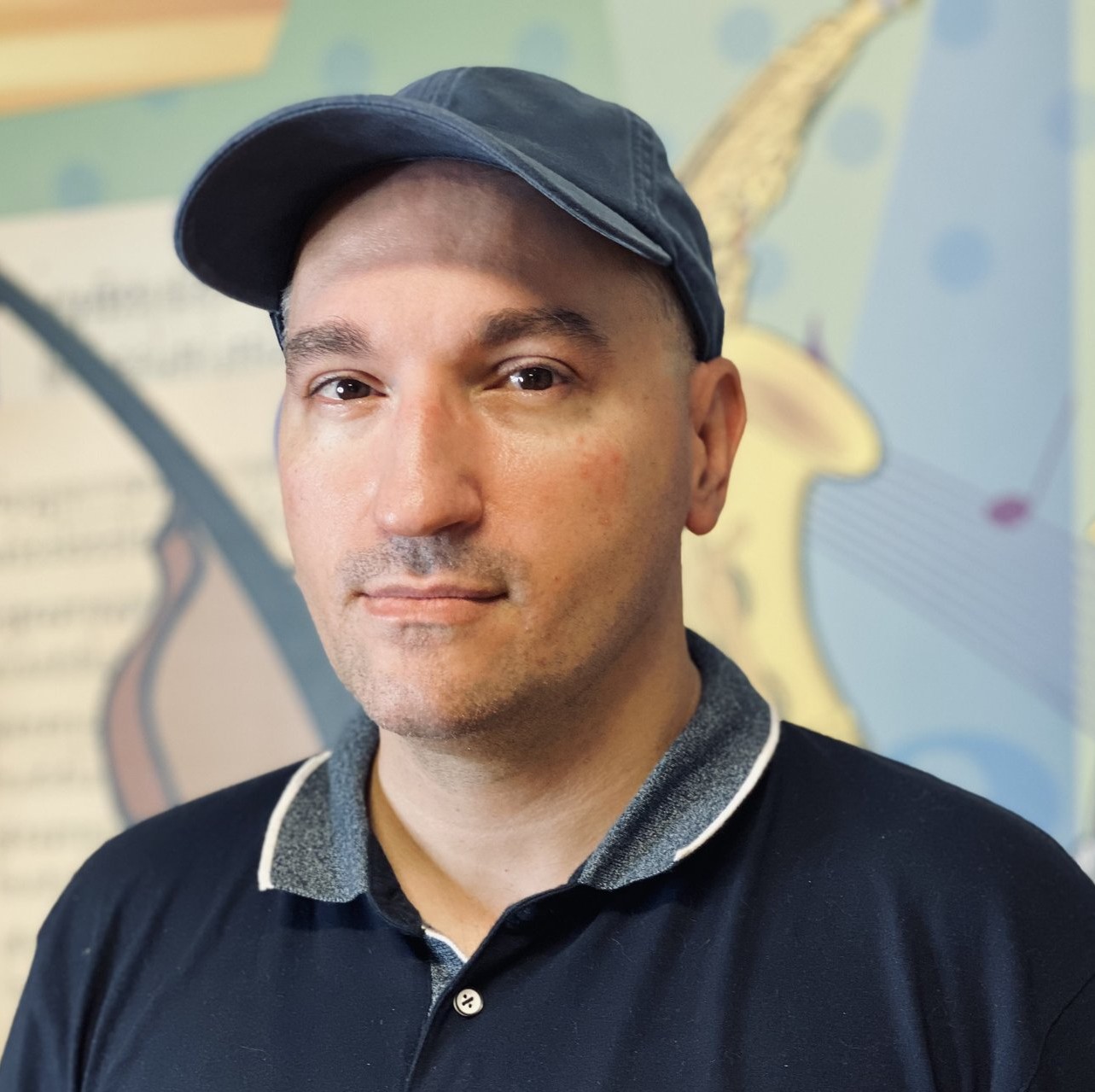 Robert Cinardi staff photo in front of colorful mural