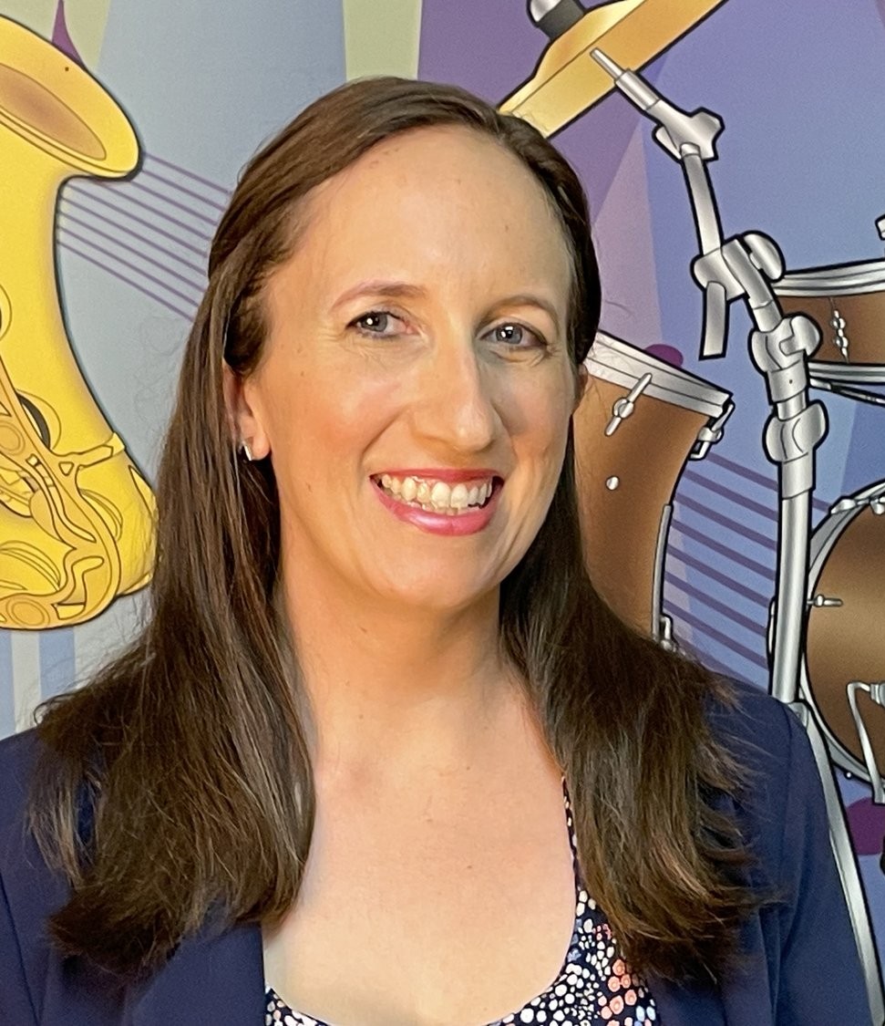 Katie Vitale smiling in front of a music-themed mural