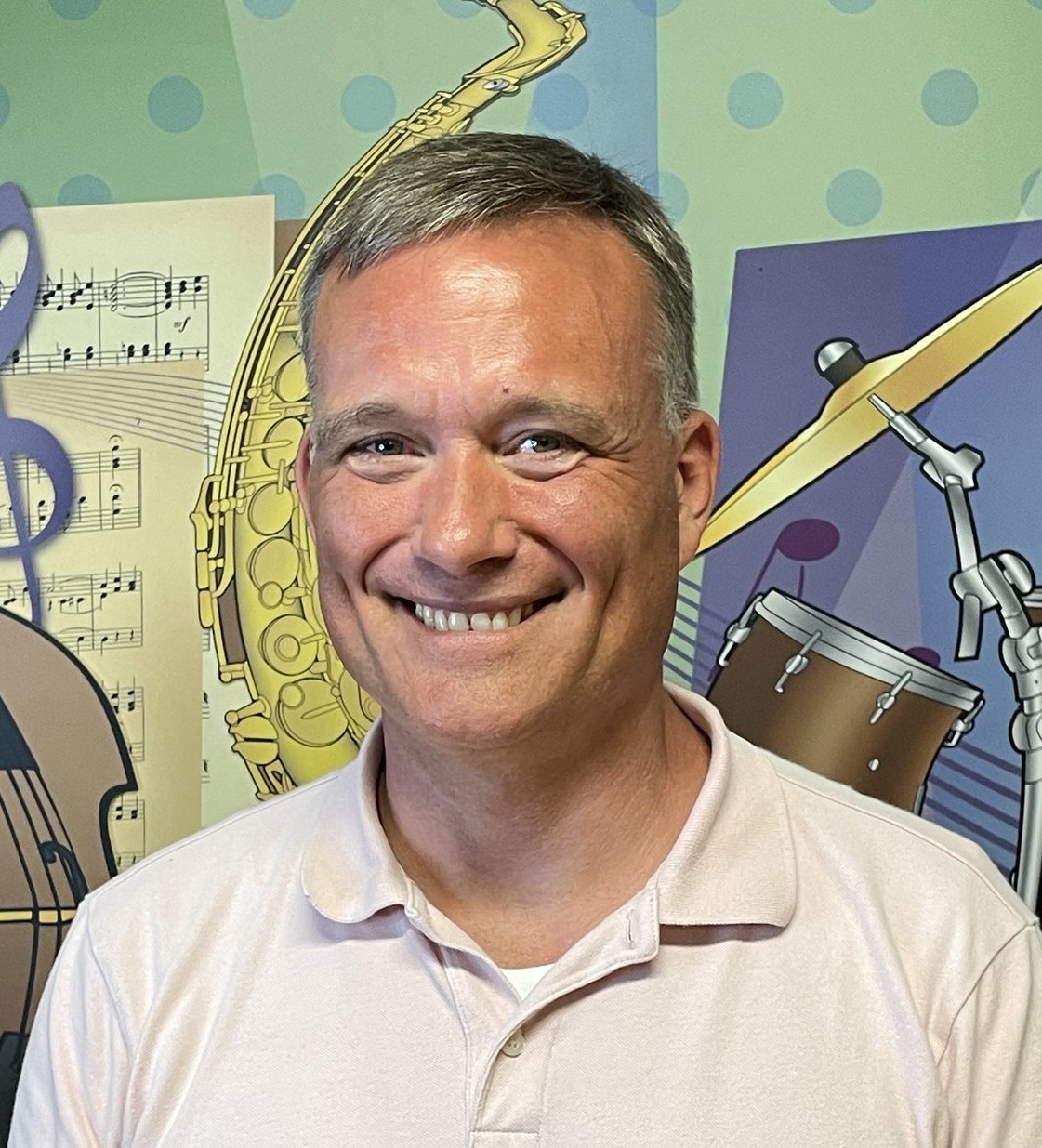 Music teacher portrait with musical instrument backdrop