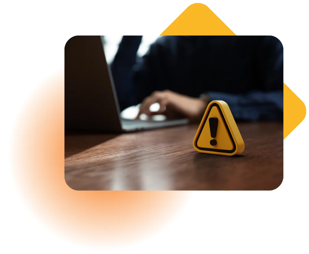 Yellow warning icon next to a laptop, representing cybersecurity and fraud prevention best practices for financial services and freight businesses