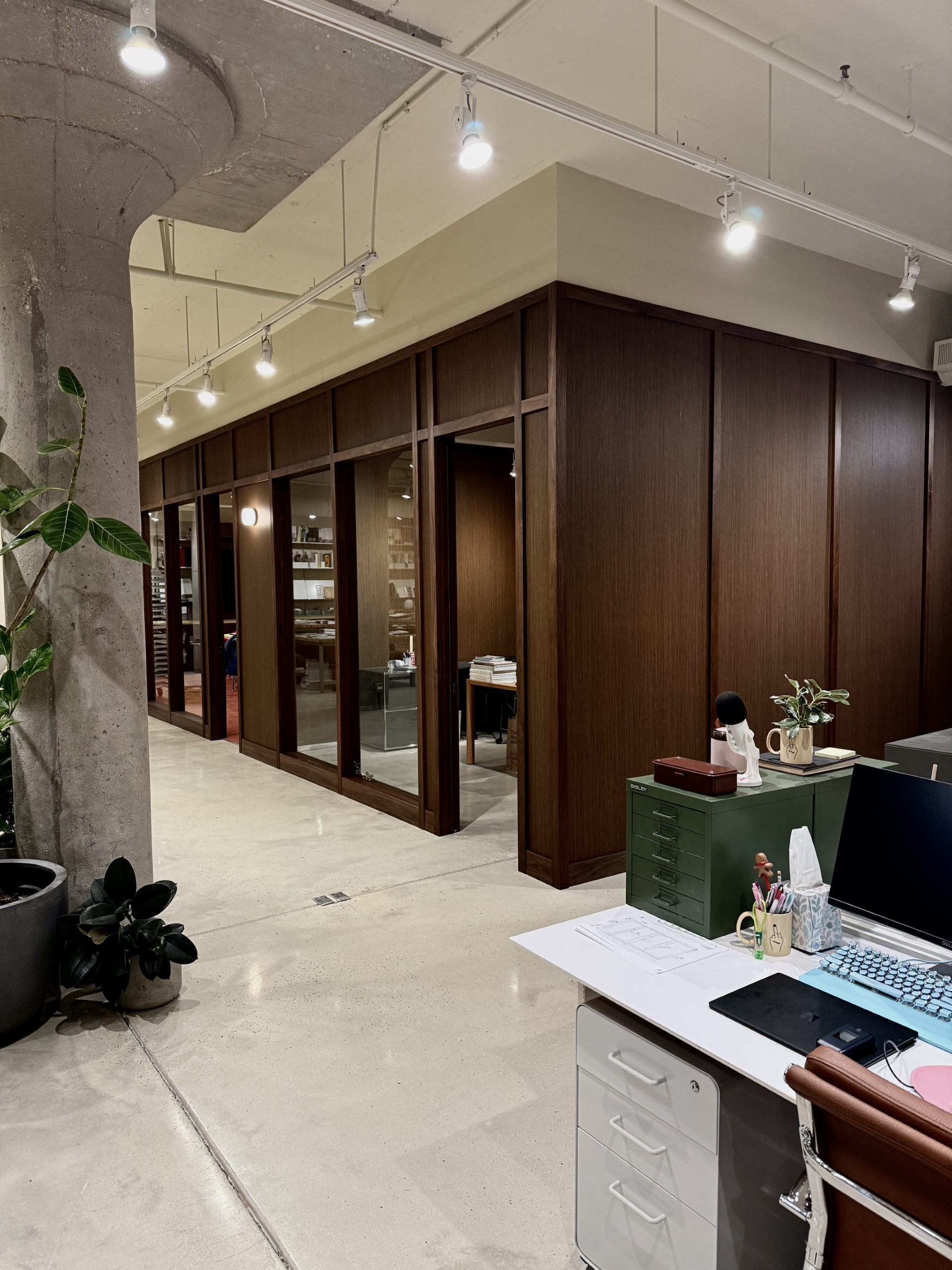 Close-up of a design detail featuring a mounted bird, artwork, plants, and decor elements on a cabinet in Avenir Creative's office.