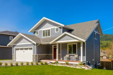 gray craftsman two-story house with garage stone accents and green lawn