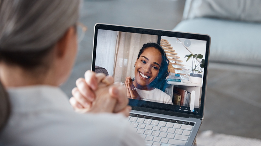 A person using a laptop to participate in a virtual consultation with a smiling healthcare provider, showcasing Haven's telehealth services.