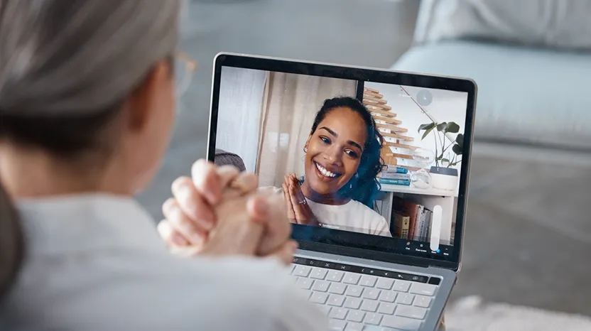 A person using a laptop to participate in a virtual consultation with a smiling healthcare provider, showcasing Haven's telehealth services.