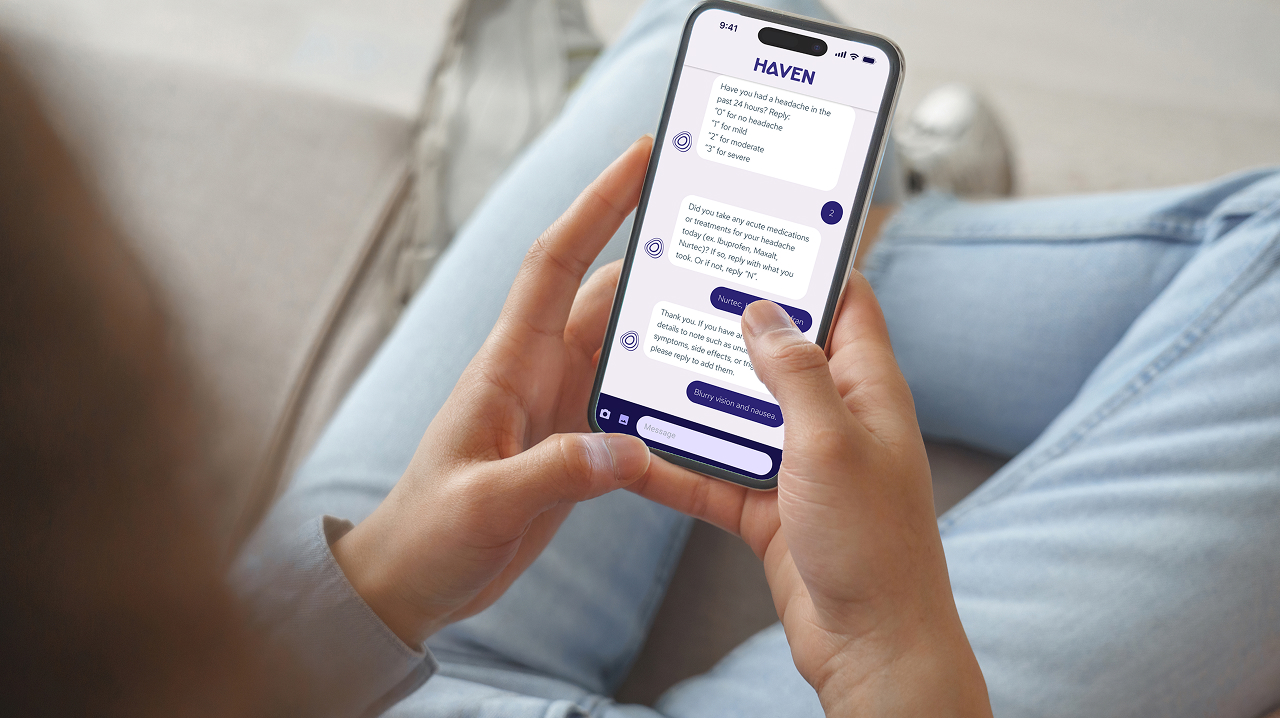 A person sitting on a couch holding a smartphone, using the Haven app to view a personalized migraine plan during a virtual consultation.