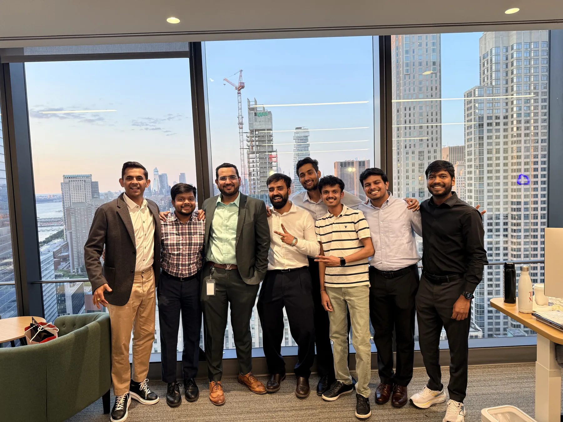Consultadd New York team posing together in front of floor-to-ceiling windows overlooking Manhattan