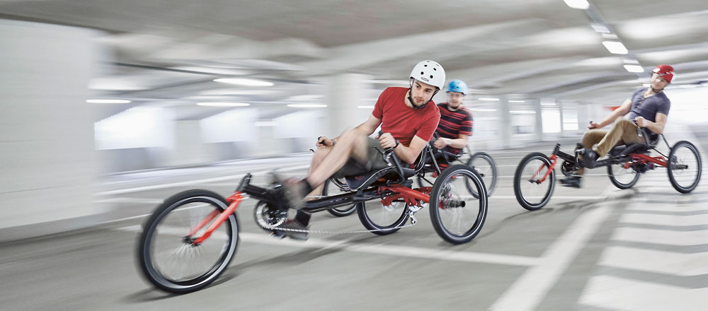 zwei Dreiräder Trigo von Hase Bikes fahren im Parkhaus