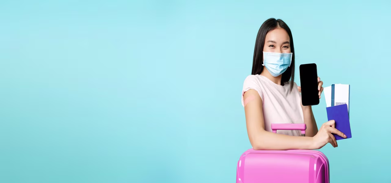 Asian female vaccinated tourist with suitcase