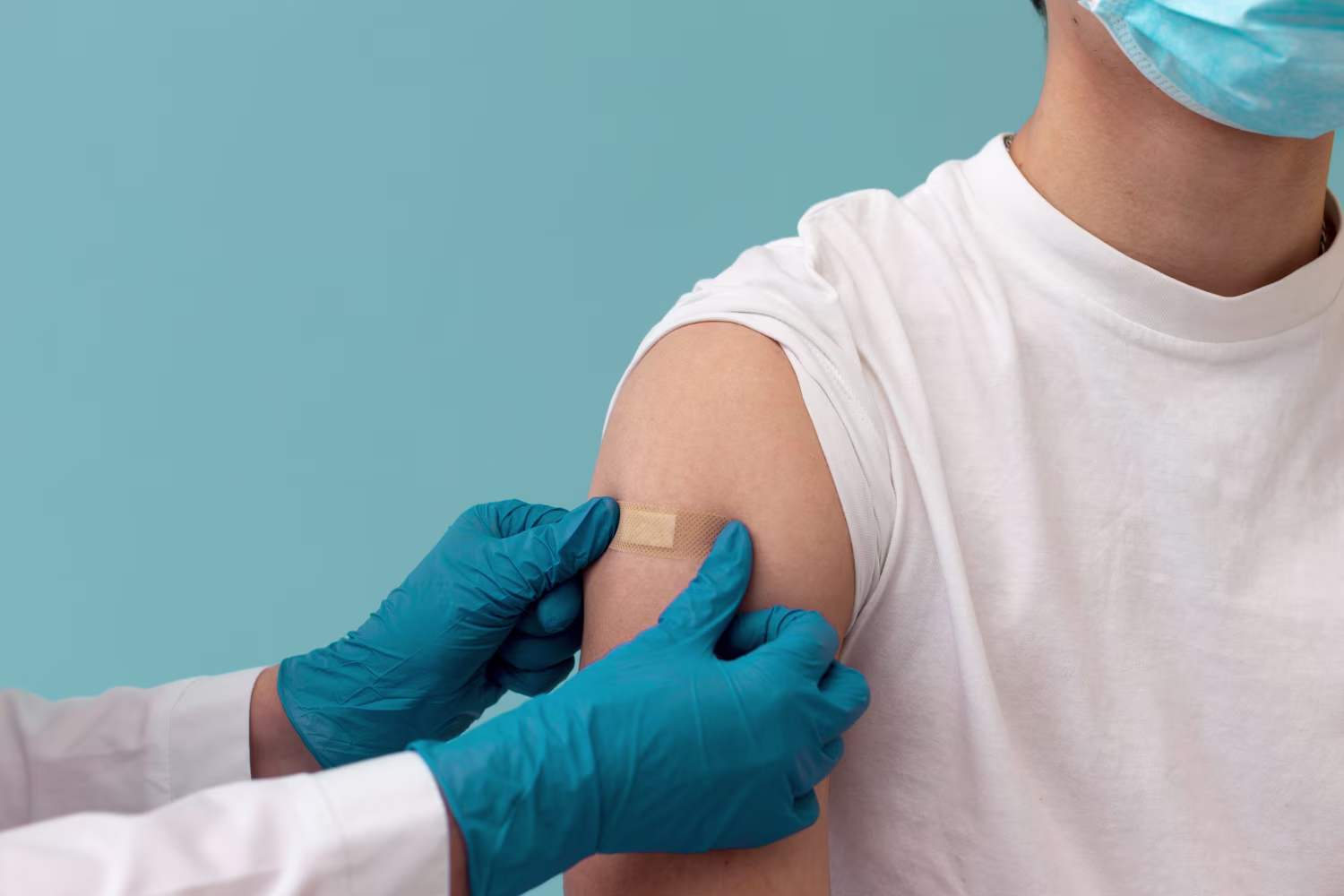  Close up hands putting on band aid after flu vaccination