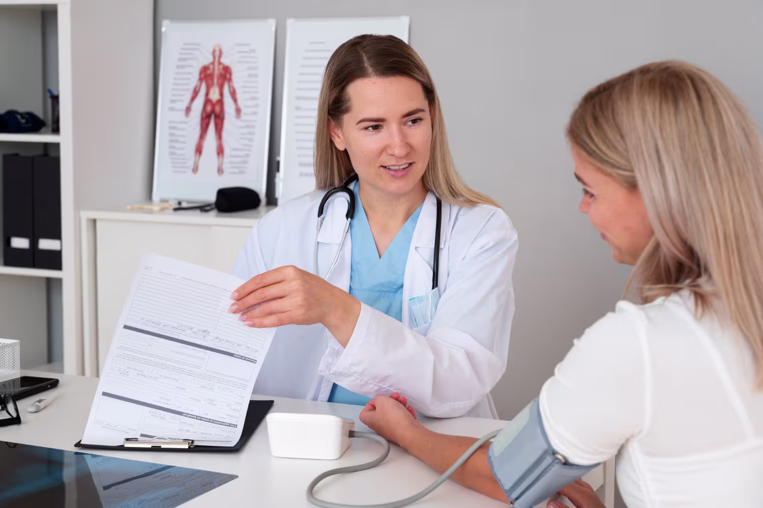 Female doctor monitoring blood pressure of a female patient