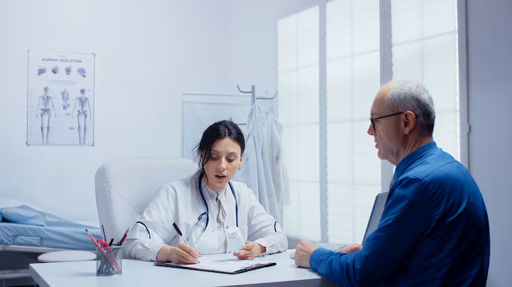 Female doctor consulting elderly retired senior man