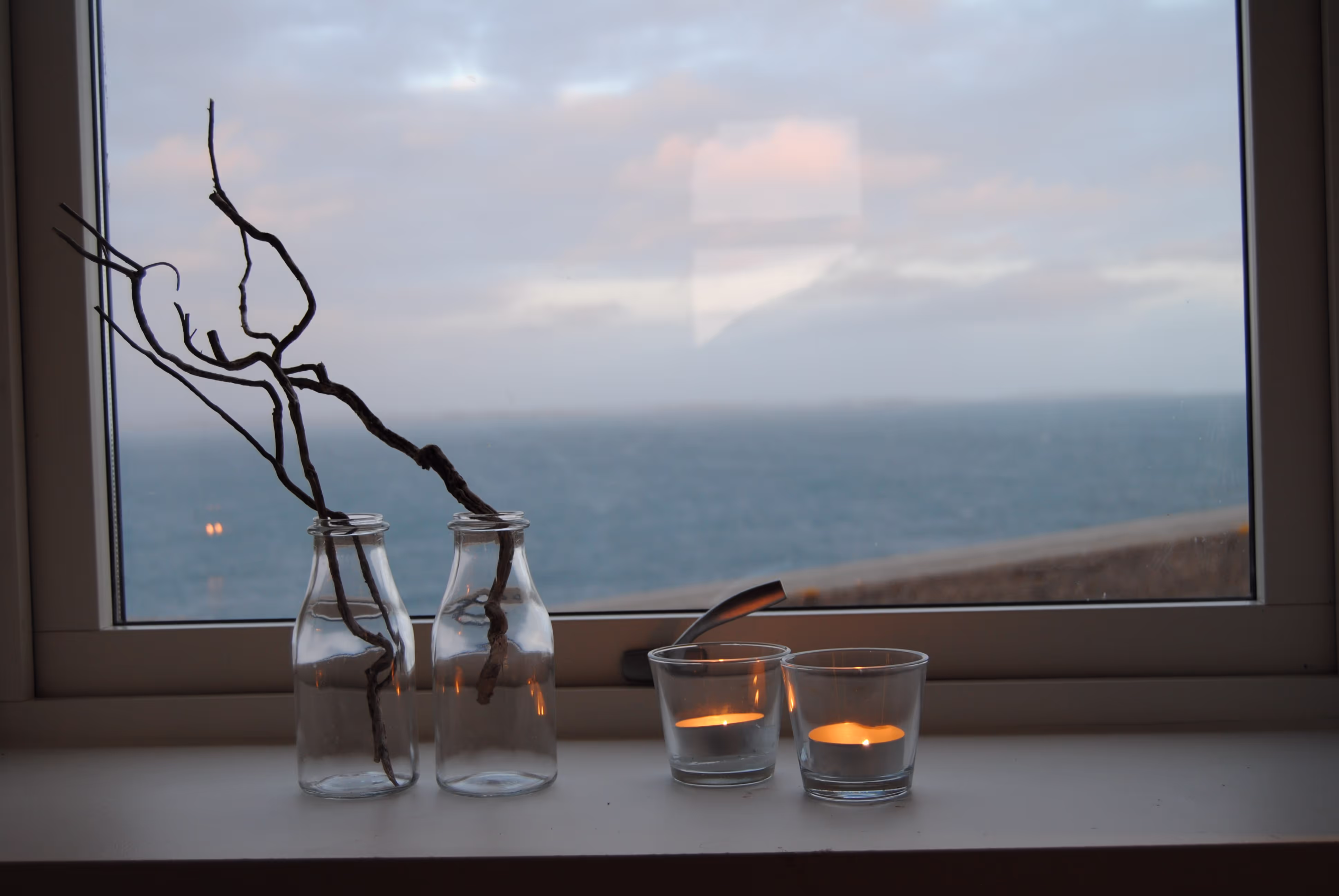 Telys i vinduet med utsikt mot havet