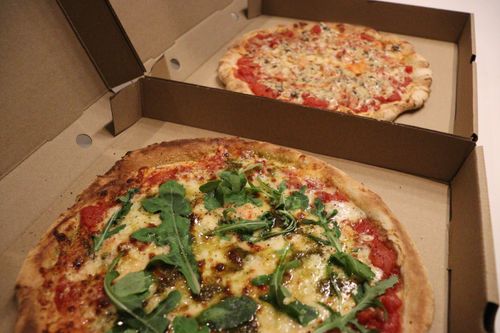 A young woman eating a piece of pizza in the car