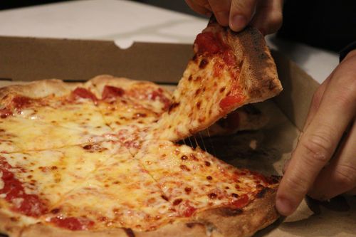 Thin pizza coming out from the oven