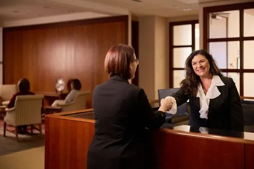 A friendly receptionist greeting someone at the Strauss Troy office.