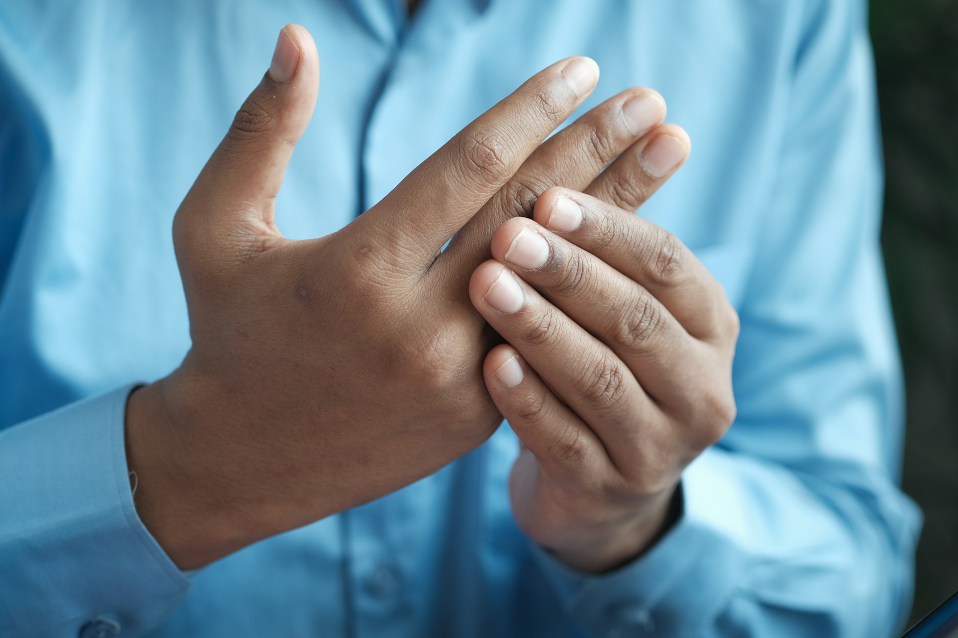 Person rubbing their hands as though experiencing joint pain