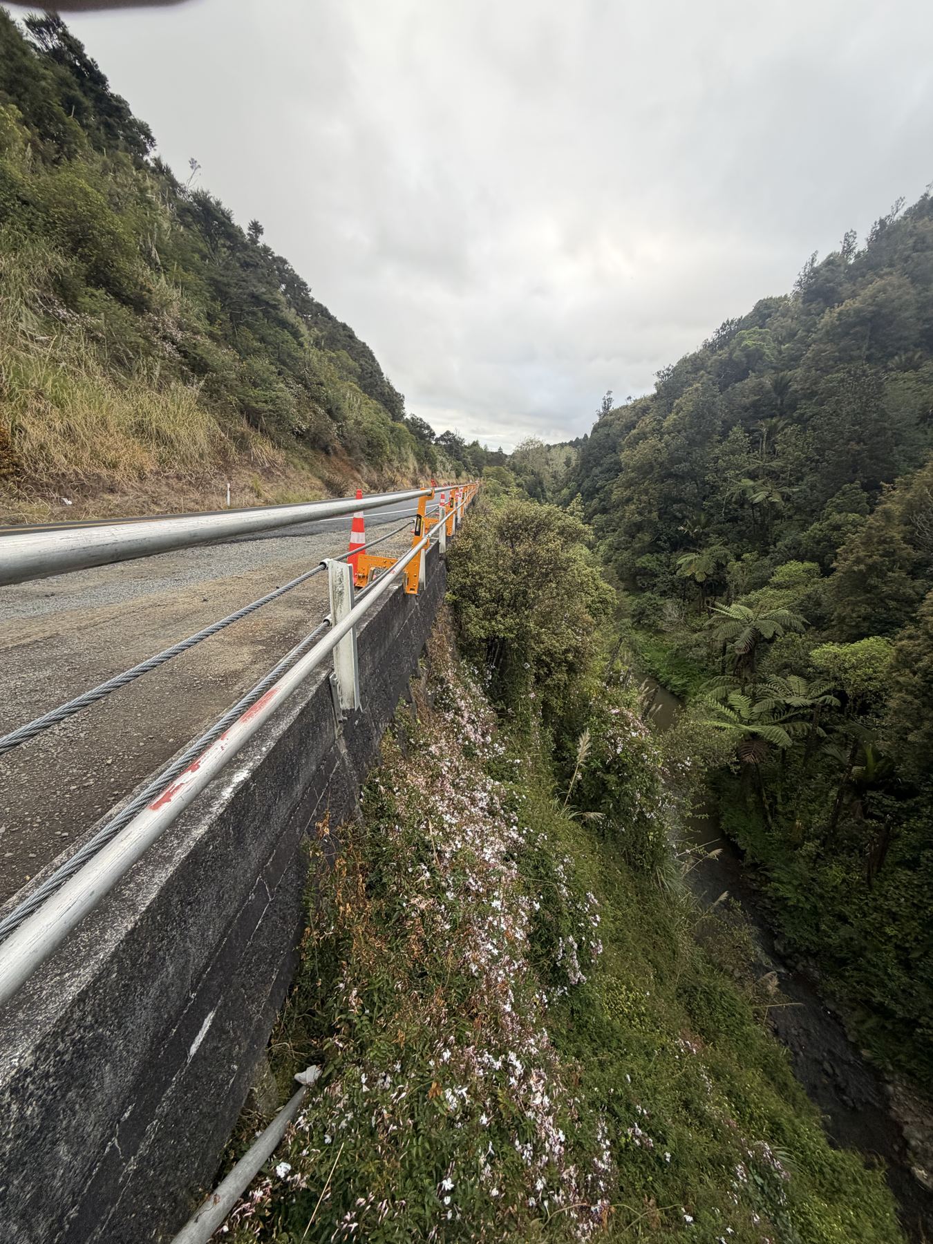Steep gorge drop beside the road edge where the guardrail was installed