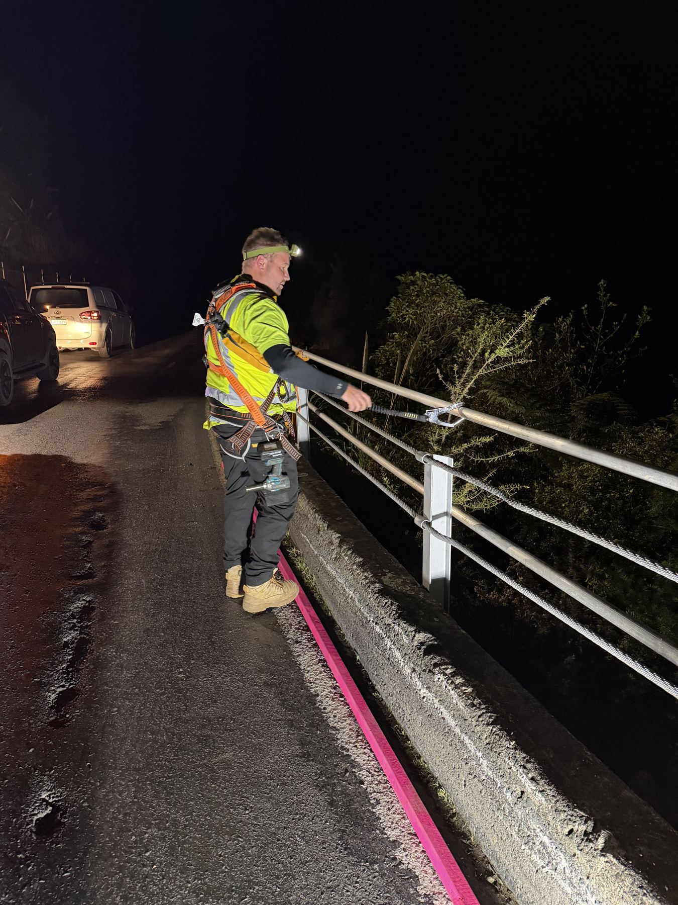 EdgeGuard crew installing roadside guardrail at night