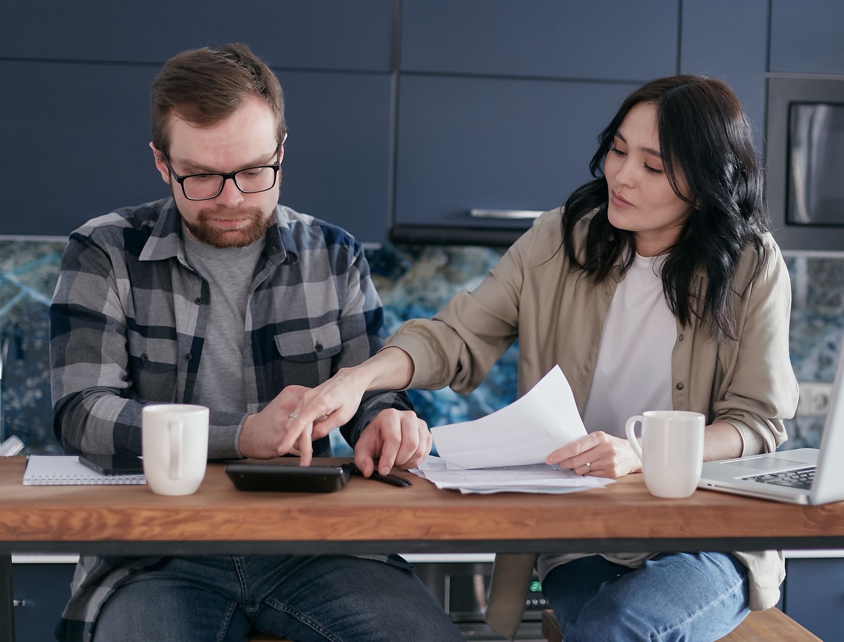 Pareja revisando sus finanzas y facturas juntos en casa