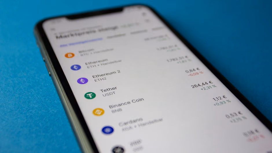 Celular mostrando cotizaciones de criptomonedas y stablecoins en tiempo real