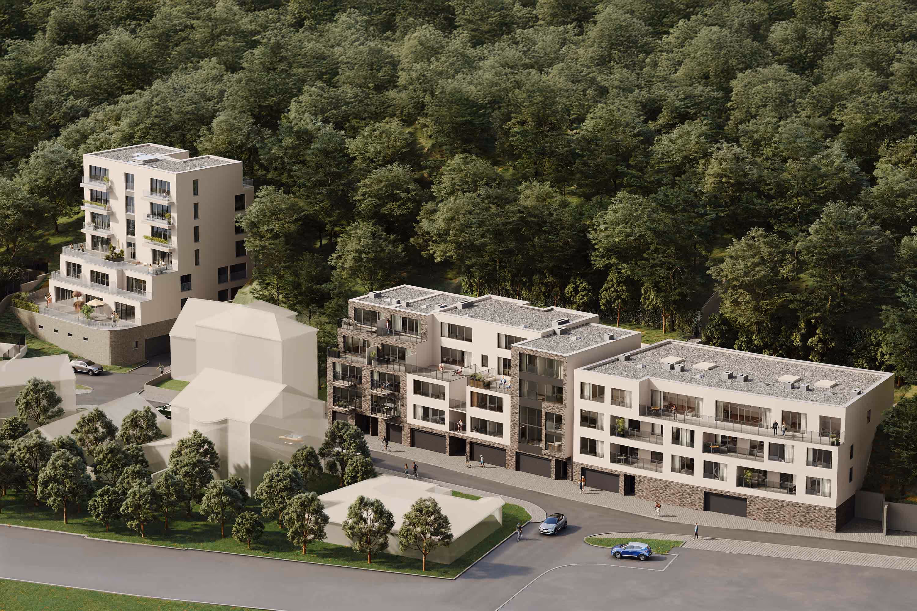 Moderní bytový komplex se stromovým porostem v pozadí a několika zaparkovanými auty, záběr z ptačí perspektivy.