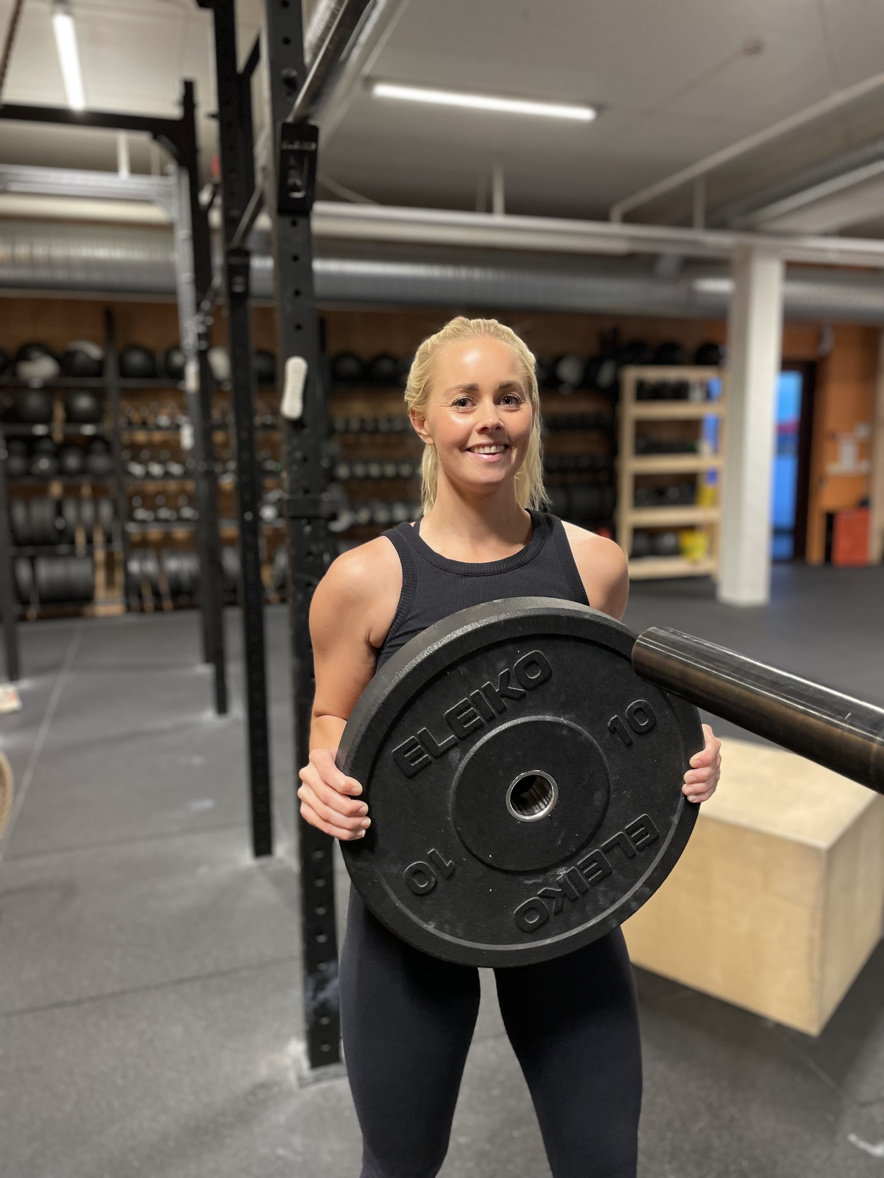 Coach som løfter vektskive opp til vektstang