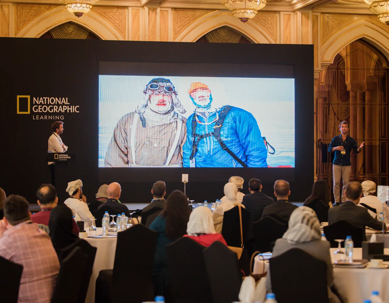The Turner Twins presenting at a National Geographic Learning event, with an expedition photo on the big screen