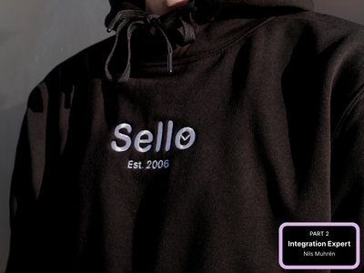 Person wearing a black hoodie with a white Sello logo on the chest.