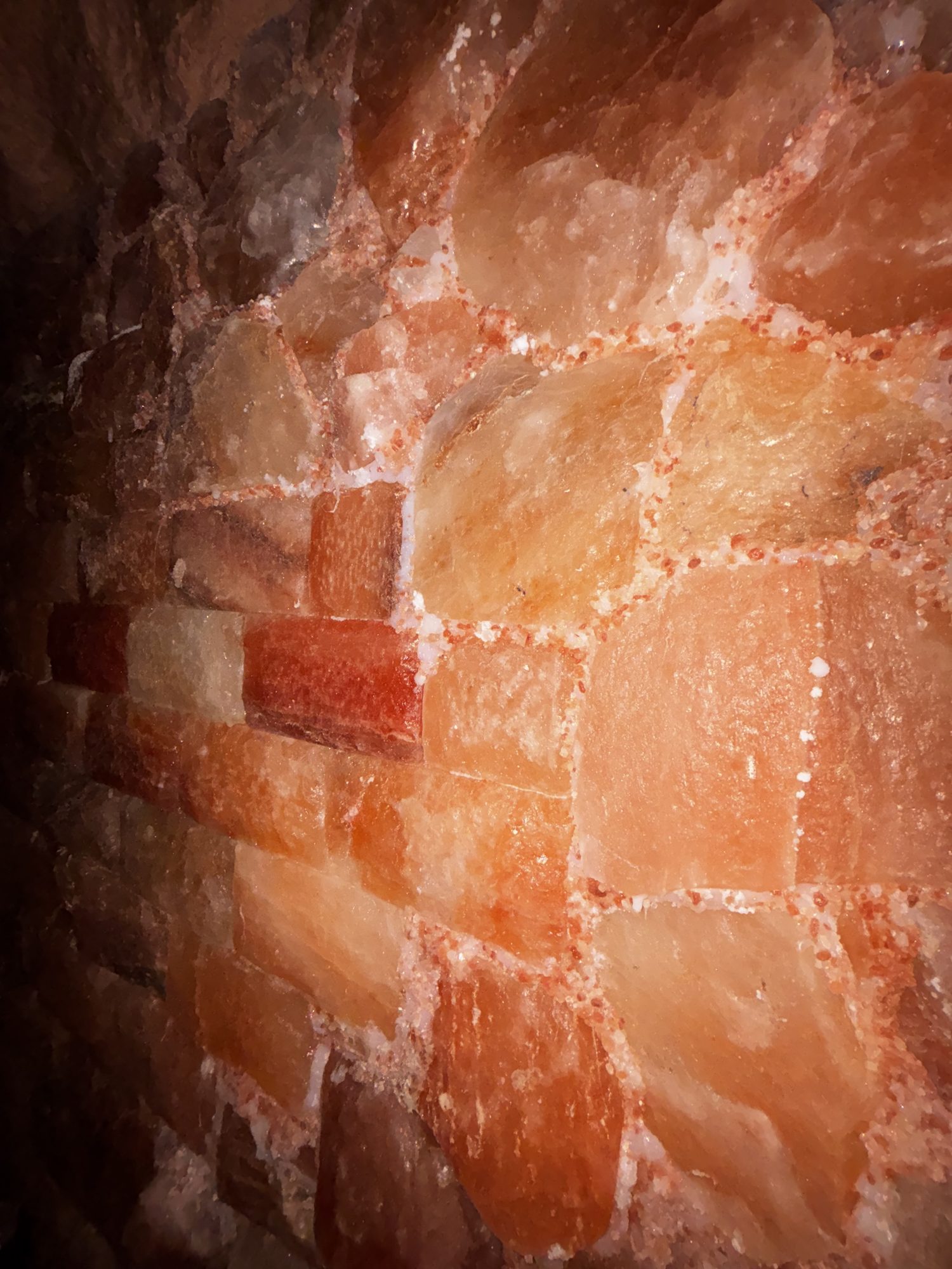 Close-up of glowing Himalayan salt block wall inside the Altered States salt cave