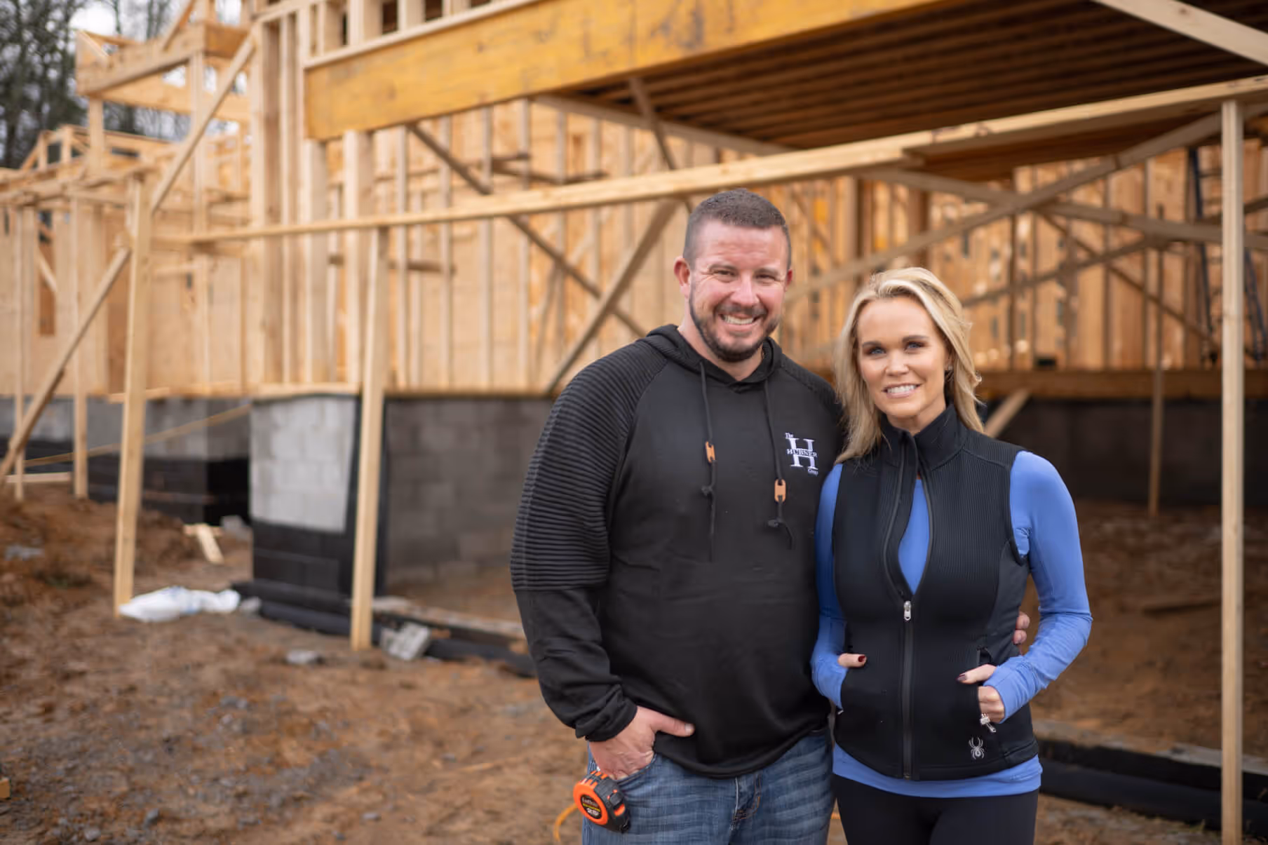 Ray and Stephanie Hubner standing inside a partially built home, representing The Hubner Group’s expertise in home construction and development.