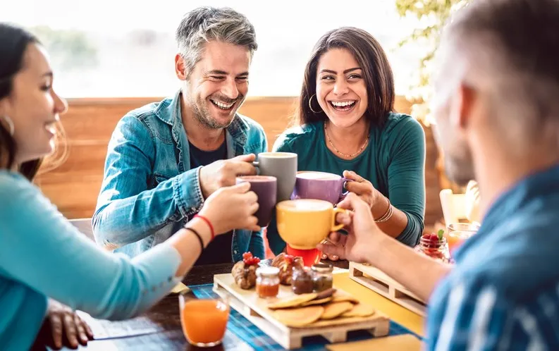 Smiling adults confidently interacting at a social event.