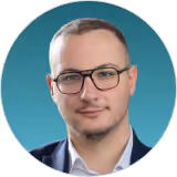 Headshot of a DualEntry team member in glasses and a dark blazer