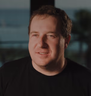 DualEntry employee in a black tee smiling during a careers video interview