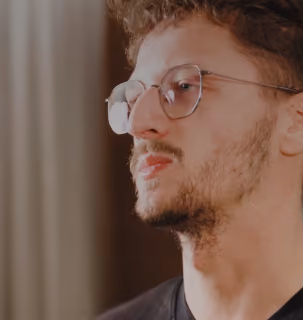 Profile view of a DualEntry engineer with round glasses from the careers video