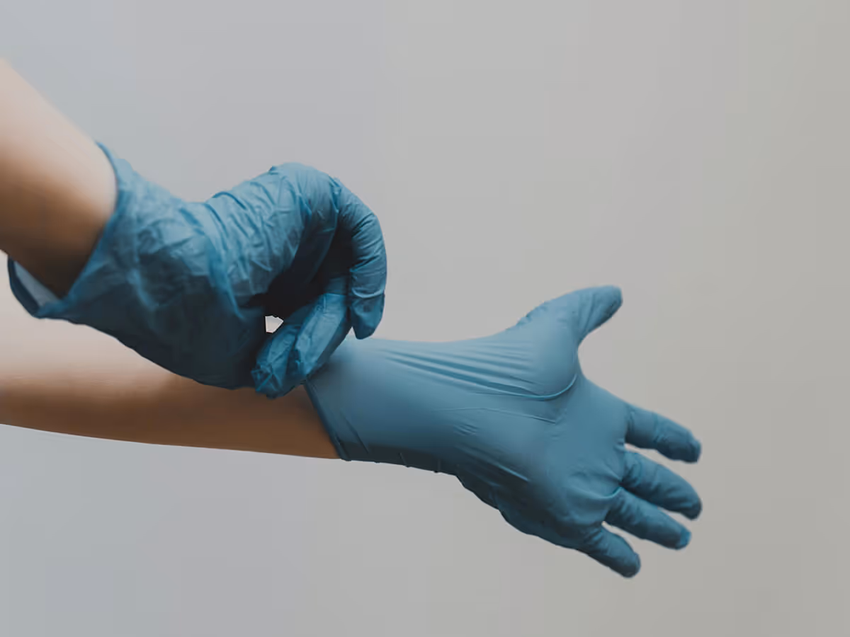 up close shot of person putting on medical gloves