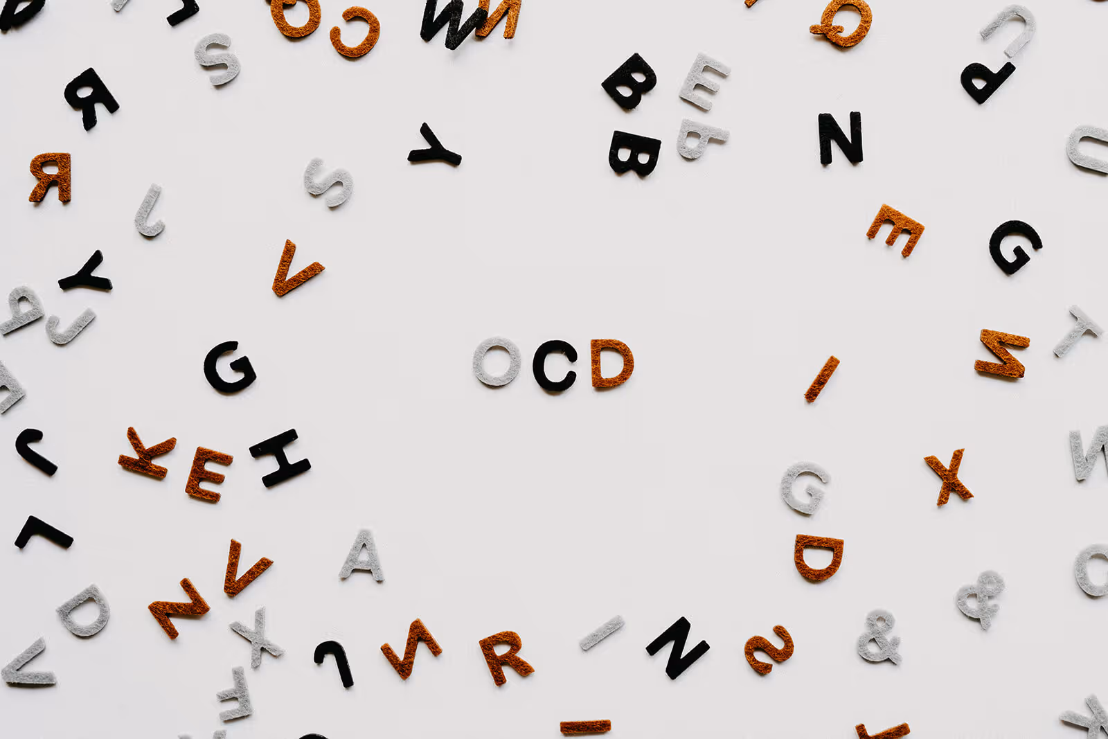 a table covered in letters with three spelling out ocd in the middle