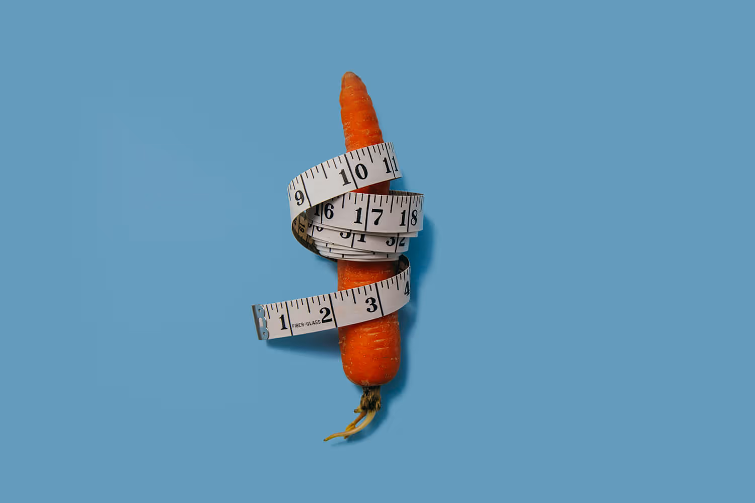a carrot wrapped tightly with a measuring tape
