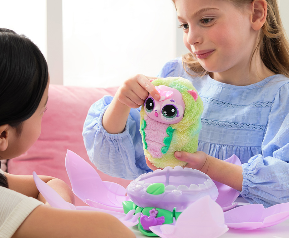 Two young girls interact with a Puppyfly Hatchipillar