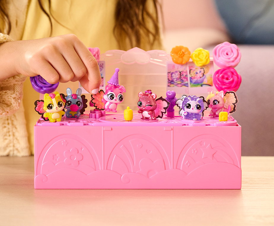 A child's hand plays with Hatchimals figures in the Bloom Bash toy