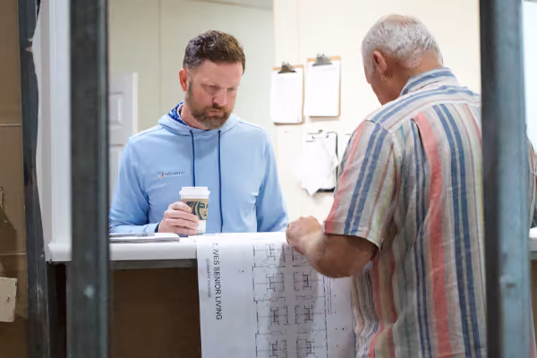 Members of the St. Ives Hometown Living of Johns Creek team review blueprints